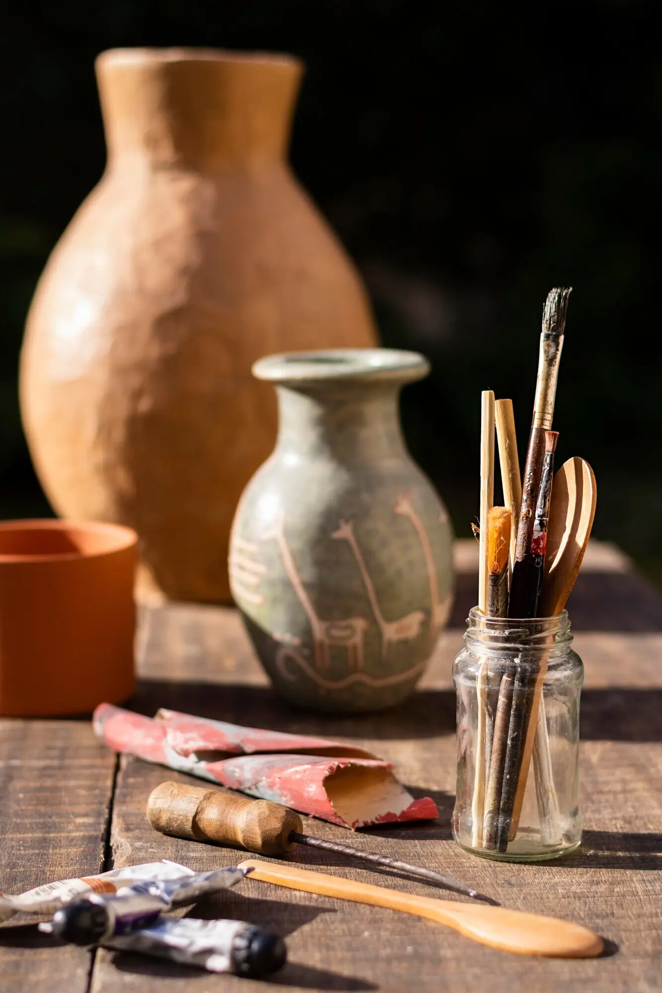 Vorderansicht: Vase und Malwerkzeuge